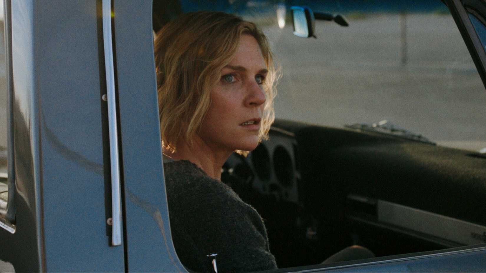 Carol in a truck looking off screen
