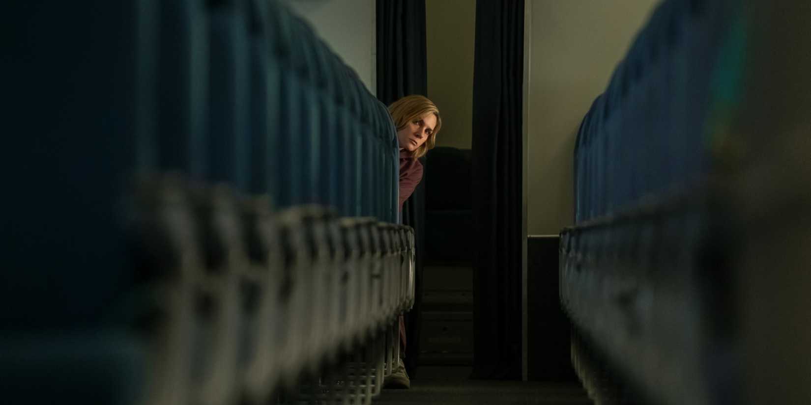 Carol on an airplane looking at rows of empty seats in Pluribus