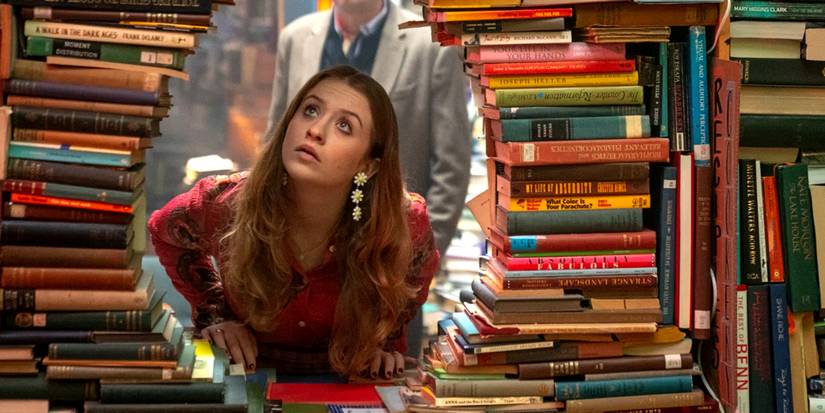 Jen looks through a hole between piles of books in Extraordinary